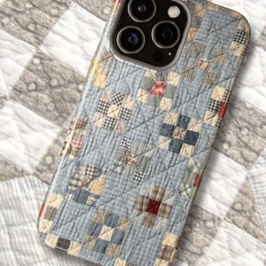 May include: A phone case with a patchwork quilt design. The case features a light blue background with squares of various patterned fabrics in shades of blue, red, and cream. The case has a glossy finish and a camera lens cutout.