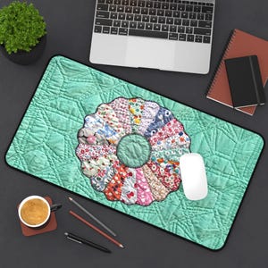May include: A rectangular mouse pad with a quilted mint green background and a colorful floral design in the center. The design is a circular pattern of various fabric scraps. A white mouse, laptop, and coffee cup are also visible.