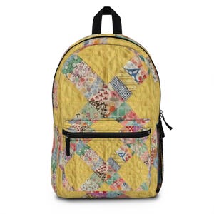 May include: Yellow backpack with a patchwork design. The backpack features a large front pocket with a black zipper, a black top handle, and a black zipper closure. The patchwork design includes floral and geometric patterns.