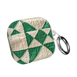 May include: AirPods case with a quilted design in green and off-white. The case has a silver-colored metal clip attached. The case is square-shaped and has a textured appearance.