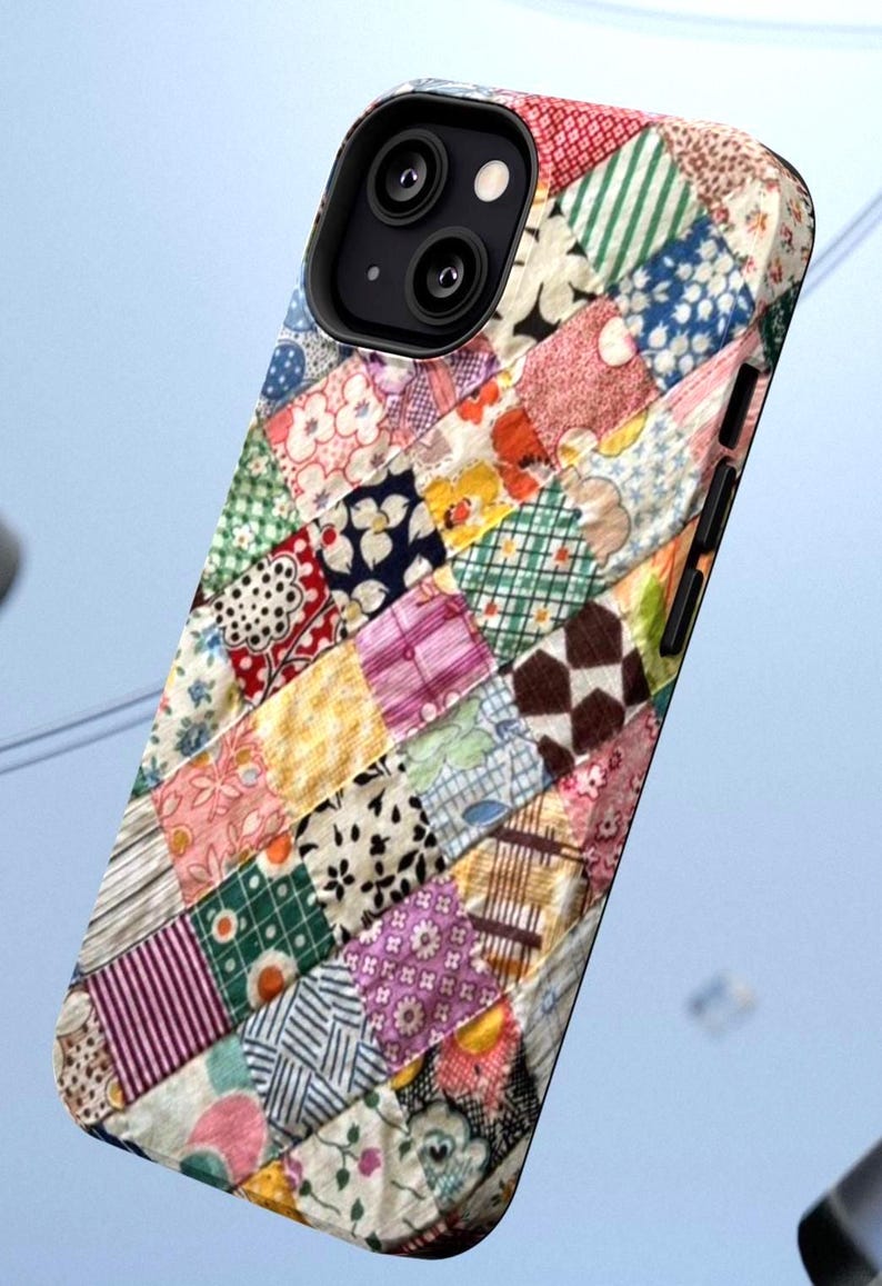 Op de afbeelding: Een smartphonehoesje met een kleurrijk patchworkontwerp bestaande uit diverse kleine vierkante stofpatronen in tinten roze, groen, blauw, geel en wit, met een zwarte uitsparing voor de camera en knoppen aan de zijkant van de behuizing.