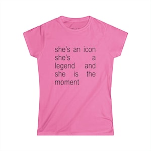 Puede incluir: Camiseta rosa brillante con el texto negro: "she's an icon, she's a legend and she is the moment". La camiseta tiene mangas cortas y cuello redondo.