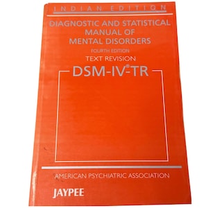 May include: A bright orange book titled Diagnostic and Statistical Manual of Mental Disorders, Fourth Edition, Text Revision, DSM-IV-TR, Indian Edition, published by the American Psychiatric Association and Jaypee, featuring white text.