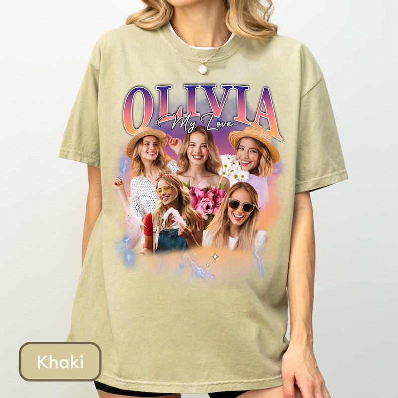 May include: A khaki-coloured t-shirt featuring a graphic print with the text "OLIVIA My Love" in a gradient font. The design includes a collage of four images of a woman wearing hats and sunglasses, surrounded by a soft purple and orange glow.