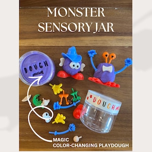 May include: A Monster Sensory Jar set with color-changing playdough. The set includes a jar, purple playdough, and various monster-themed accessories. The text "Monster Sensory Jar" and "Magic Color-Changing Playdough" are visible.