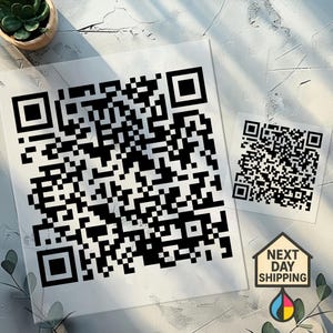 May include: Two black and white QR codes, one large and one small, printed on white paper. A small sign with the words "NEXT DAY SHIPPING" and a CMYK color droplet is in the lower right corner.