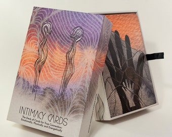 Può includere: Una scatola di carte sull'intimità con un design di tramonto viola e arancione sul davanti. Il testo sulla scatola recita "INTIMACY CARDS The Deck of Cards for True Connection: Emotionally, Physically and Energetically."