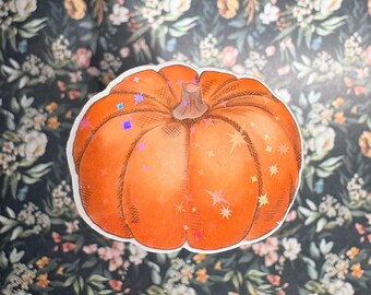 May include: A die-cut sticker featuring a round, orange pumpkin with a brown stem. The surface of the pumpkin is decorated with holographic star-shaped accents that reflect light, creating a shimmering effect against the solid orange colour.