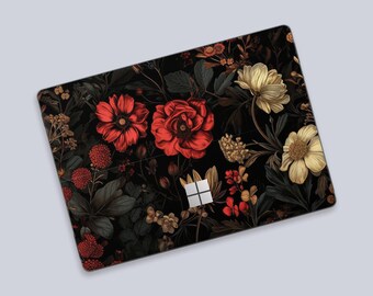 May include: A laptop skin featuring a dark black background with a dense botanical pattern of vibrant red and pale yellow flowers, green foliage, and small buds. The Microsoft logo is visible in the center of the rectangular device cover.