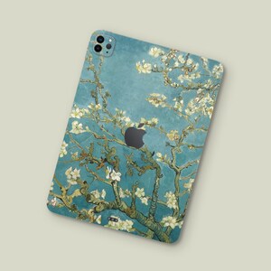 May include: A blue and green phone case with a floral design. The design features white flowers and green branches against a blue background.