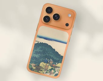 May include: A peach-colored phone case featuring a Japanese landscape painting. The case has a rectangular design with a scenic image of a mountain, water, and people. The phone case has a camera module with three lenses and a flash.