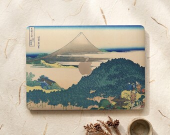 May include: A rectangular laptop skin featuring a reproduction of a Japanese woodblock print depicting Mount Fuji, a dense forest, and small figures. The design includes a central cutout for an Apple logo and vertical Japanese text on the left.