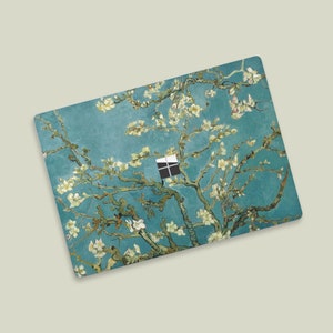 May include: A laptop skin featuring a painting of a blooming almond tree with white flowers against a blue sky. The skin is designed to fit a laptop with a standard-sized screen.