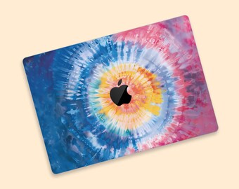 May include: A laptop skin featuring a tie-dye design in shades of blue, pink, yellow, and orange. The Apple logo is visible in black. The design has a circular pattern, with the colors blending together.
