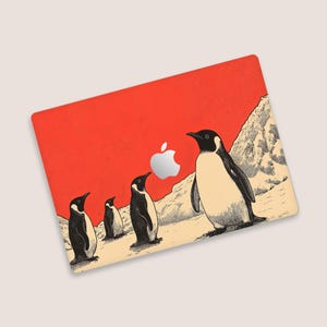 May include: A red and white laptop skin featuring a graphic of four penguins walking on a snowy landscape. The penguins are black and white with orange beaks. The skin has a distressed, vintage look.