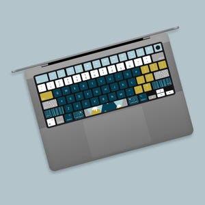 May include: A gray laptop computer with a keyboard featuring a blue, yellow, and white patterned design. The keyboard has a variety of keys with different patterns and colors.