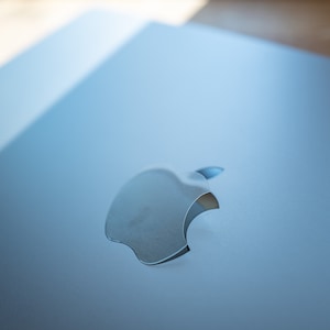 Puede incluir: Un portátil plateado con el logotipo de Apple en la tapa.