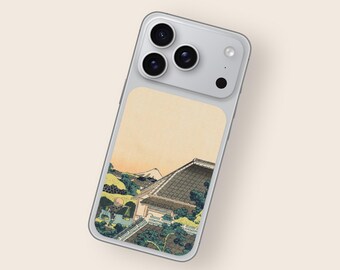 May include: A silver smartphone case featuring a Japanese landscape design. The artwork depicts a traditional building with a tiled roof, surrounded by lush greenery and a mountain in the background, set against a warm, yellow sky.