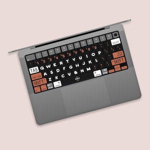 May include: A black laptop keyboard with orange and white keys. The keys are labelled with letters and numbers. The keyboard has a trackpad and a silver case.