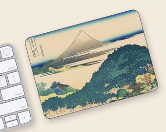 May include: Rectangular mousepad featuring a Japanese landscape print with Mount Fuji in the background. The artwork includes a blue sky, green trees, and traditional Japanese buildings. The mousepad is placed next to a computer keyboard.