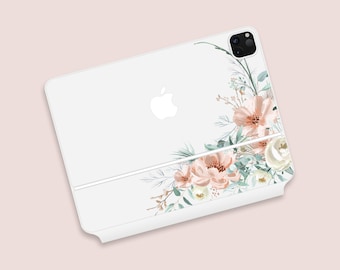May include: White iPad case with a floral design. The case features a corner arrangement of peach and white flowers with green leaves. The Apple logo is visible on the top left corner of the case.
