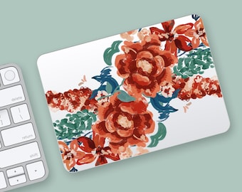 May include: White rectangular mousepad featuring a floral design. The design includes large, stylized red and orange flowers with green and blue leaves. A computer keyboard is partially visible in the image.