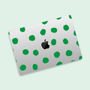 May include: A white laptop with a green polka dot pattern. The Apple logo is visible on the laptop.
