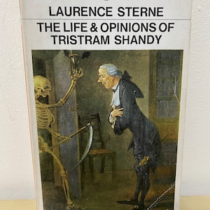May include: A Penguin English Library paperback book cover featuring an illustration of a skeleton holding a scythe and a man in a blue suit looking at the skeleton. The book title is "The Life & Opinions of Tristram Shandy" by Laurence Sterne.