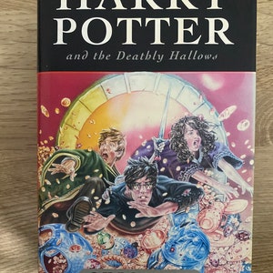 Puede incluir: Una portada de libro para "Harry Potter y las Reliquias de la Muerte" de J.K. Rowling. La portada presenta una ilustración de Harry Potter, Ron Weasley y Hermione Granger corriendo por una habitación llena de monedas de oro y otros objetos.