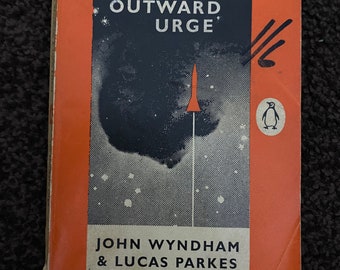 May include: A vintage Penguin Books paperback cover with an orange background. The title is "The Outward Urge" by John Wyndham & Lucas Parkes. The cover features a rocket ship and a penguin logo.