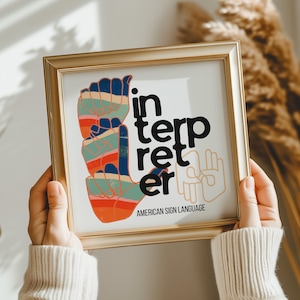Puede incluir: Un cuadro enmarcado con la palabra «interpreter» en texto negro y una colorida ilustración de la mano en lenguaje de señas americano. Las palabras «American Sign Language» están impresas en la parte inferior.