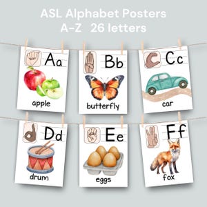 May include: A set of six ASL alphabet posters, each featuring a letter, a corresponding hand sign, and a watercolor illustration. The posters are suspended from a clothesline. The text "ASL Alphabet Posters A-Z 26 letters" is at the top.