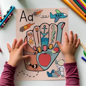 May include: An educational poster with the letter "Aa" and illustrations of objects beginning with "A", such as an apple, ant, and astronaut. The poster is held by a child's hands, with crayons and coloured pencils in the background.