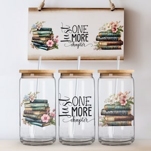 Puede incluir: Tres vasos de vidrio transparente con tapas de bambú y pajitas blancas. Cada vaso presenta una pila de libros antiguos con detalles florales y el texto "Just One More Chapter".