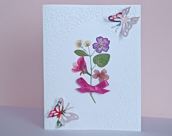 Two butterflies and a bouquet of pressed flowers, in a particular, unique card, meticulously made for weddings or anniversaries.