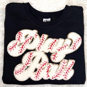May include: Black sweatshirt with a white and red embroidered baseball-themed graphic that says "Play Ball".