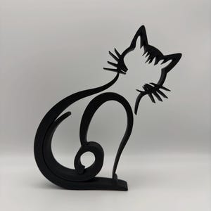 May include: Black silhouette of a cat sitting with its tail curled around its body. The cat is made of wood and has a simple, modern design.