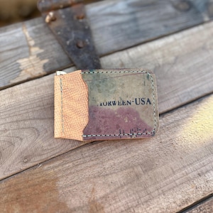 Op de afbeelding: Een bruine leren portemonnee met een camouflagepatroon en de tekst "MORWEEN-USA" aan de voorkant.