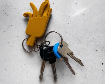 May include: A yellow 3D printed hand keyring with a silver key ring and four keys attached. The keys have blue and silver accents.