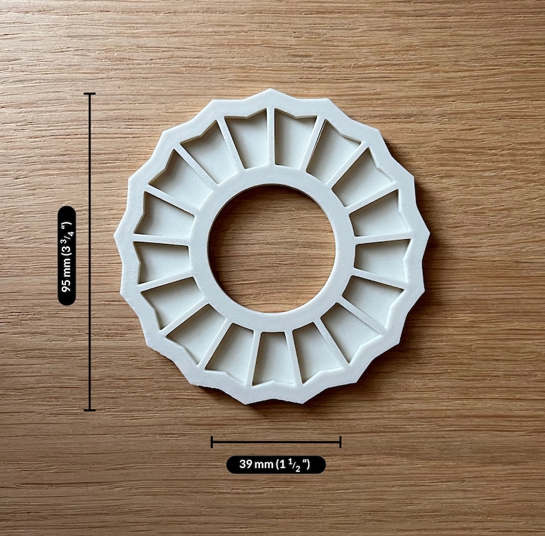 May include: White plastic mould with 16 sections in a circle shape. The mould is 9.5 cm in diameter and 3.9 cm wide.