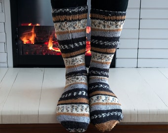 May include: A pair of warm, cozy socks with a black, brown, and white striped pattern. The socks are made of a soft, knitted fabric and are perfect for keeping your feet warm during the cold winter months.