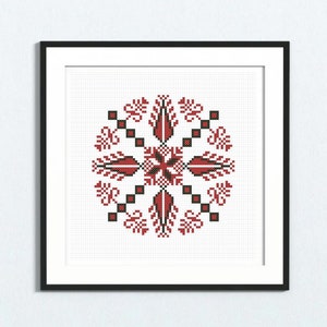 Può includere: Un ricamo a punto croce incorniciato con un motivo floreale rosso e nero. Il motivo è simmetrico e presenta una forma a stella centrale.