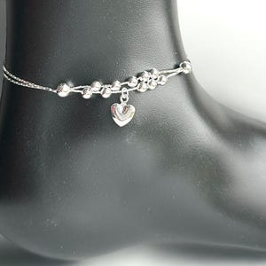 Può includere: Braccialetto per caviglia in argento con ciondolo a forma di cuore e una doppia fila di perline.