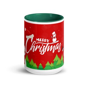 May include: A white ceramic mug with a red background and a green interior. The mug features the words "Merry Christmas" in white script, along with illustrations of snowmen and Christmas trees.
