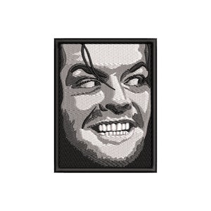 Peut inclure: Patch brodé en noir et blanc d'un visage d'homme avec un sourire sinistre. L'homme a les cheveux noirs et une mâchoire saillante. Le patch est entouré d'une bordure noire.