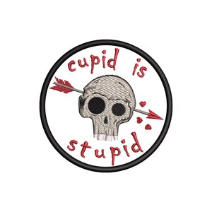 Könnte beinhalten: Gestickter Aufnäher mit einem grauen Totenkopf, durchbohrt von einem roten Pfeil, umgeben von den Worten "cupid is stupid" in roter Schrift. Das Design befindet sich auf weißem Hintergrund in einem schwarzen Kreis, mit kleinen roten Herzen.