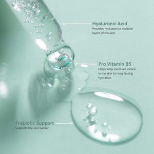 Puede incluir: Primer plano de un suero transparente que se dispensa de un cuentagotas. El suero contiene &aacute;cido hialur&oacute;nico, provitamina B5 y soporte prebi&oacute;tico. El texto de la imagen indica que el suero proporciona hidrataci&oacute;n y apoya la barrera cut&aacute;nea.