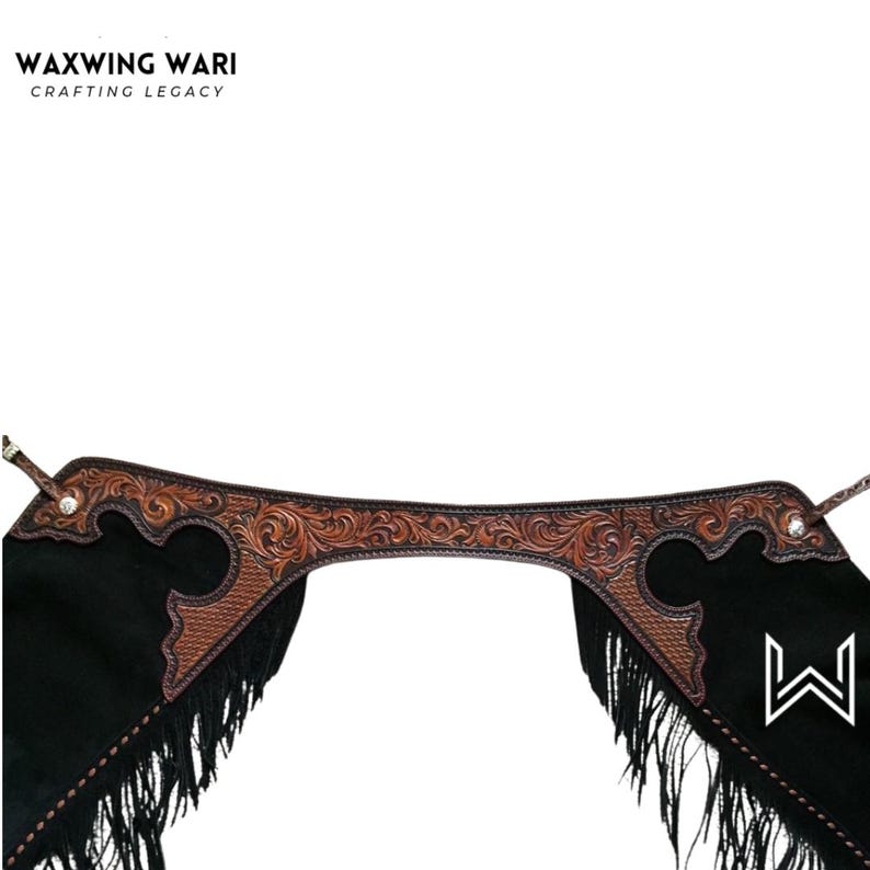 May include: Black leather chaps with brown tooled leather accents and fringe. The chaps feature a decorative floral pattern and the brand name "WAXWING WARI" at the top.