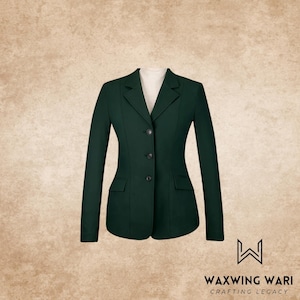 Pode incluir: Um blazer verde escuro com um corte sob medida, com lapela entalhada, dois bolsos frontais e três botões. O casaco é exibido em um fundo neutro. O nome da marca "WAXWING WARI" é visível na parte inferior.