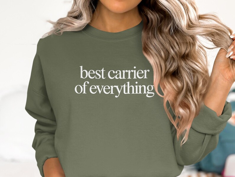 Olive green sweatshirt with "best carrier of everything" text.